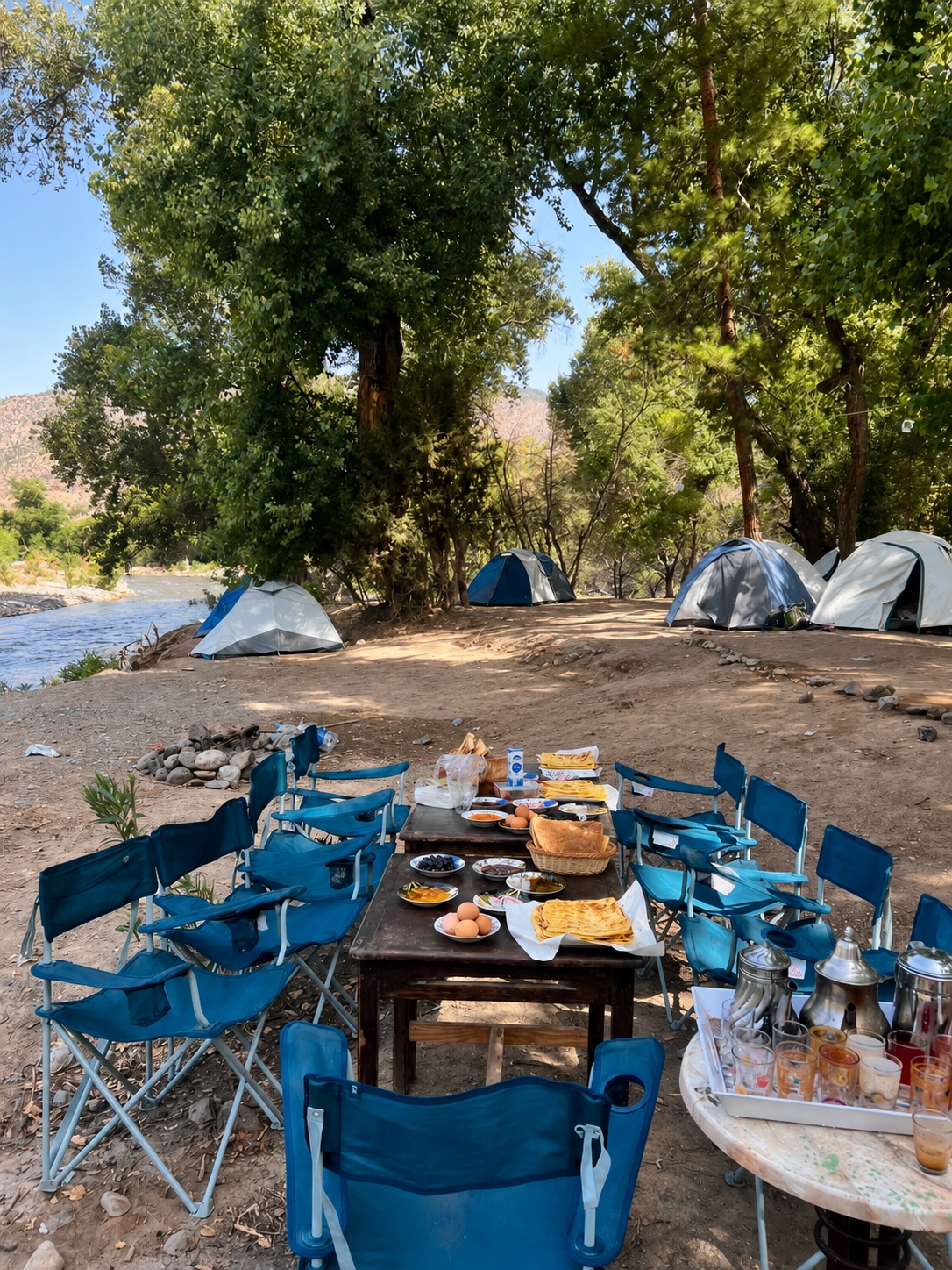 Comida al aire libre con mesa y sillas en el campamento junto al Ahansal