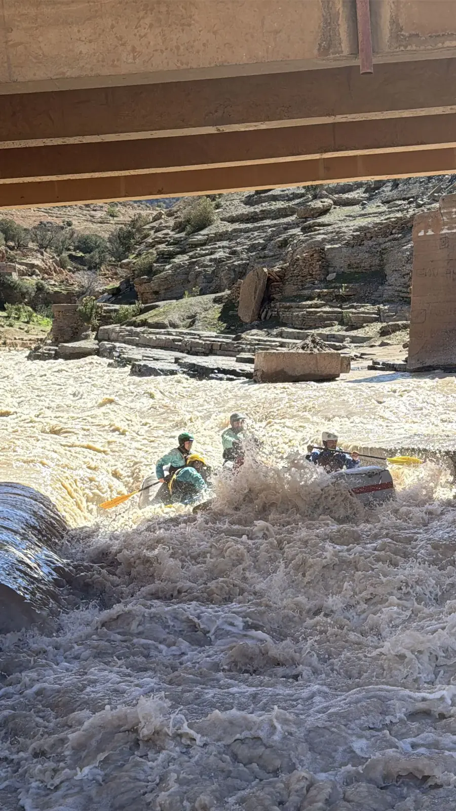 Rafting en aguas bravas bajo un puente